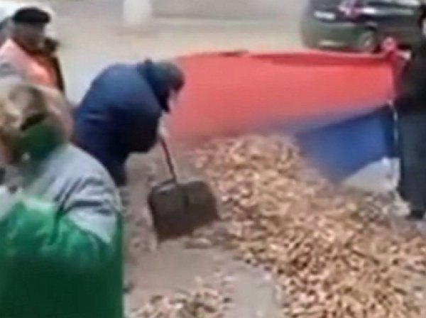В Сети появилось видео, как дворники убрали улицу с помощью флага России
