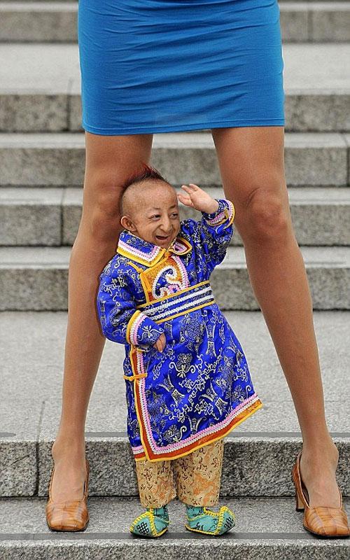 Самый маленький мужчина в мире затерялся между самых длинных женских ног