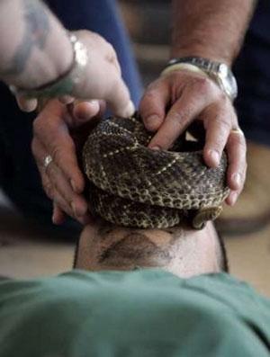 Змеиный человек держит змей у сердца