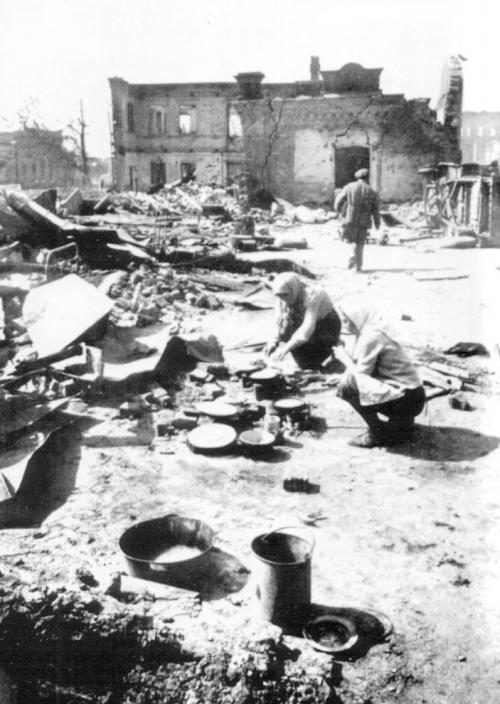 Жители Сталинграда готовят пищу у развалин своего дома, разрушенного немецкими бомбардировками.