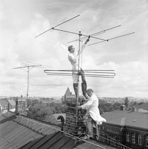 Заря телевидения в Швеции, 1953 г. Двое мужчин в белых халатах монтируют антенну.