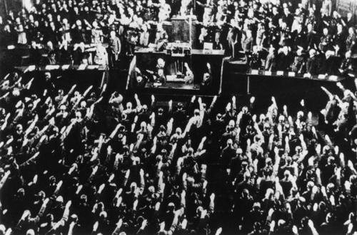 23 марта 1933 года. Члены Рейхстага поднимают руки в нацистском приветствии во время утверждения декрета «О ликвидации бедственного положения народа и государства», который передавал чрезвычайные полномочия имперскому правительству во главе с рейхсканцлером Адольфом Гитлером.