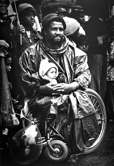 1977
Издание: Chattanooga News-Free Press
Автор: Робин Худ (Robin Hood)
Инвалид войны во Вьетнаме Эдди Робинсон со своим ребенком на параде вооруженных сил США в Чаттануге, штат Теннеси, 15 мая 1976 года.