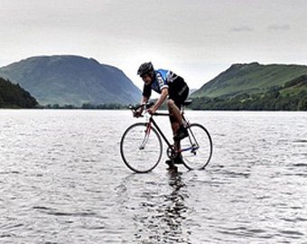 Подросток проехал по озеру на велосипеде