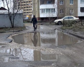 Жительница Запорожья прикрыла яму на дороге ковром