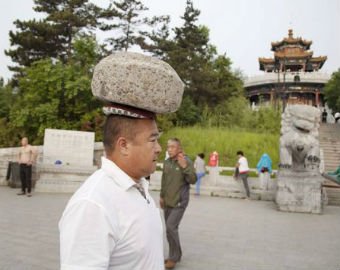Китаец гуляет с 40-килограммовым камнем на голове ради похудения