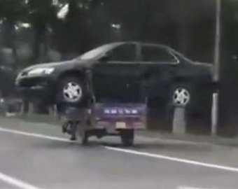 Автолюбитель «прокатил» свою машину на мотоцикле