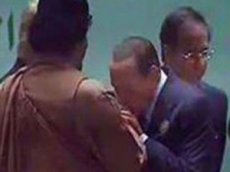 Берлускони поцеловал руку Каддафи