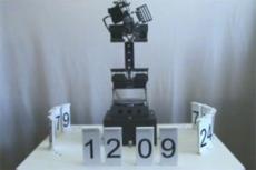 Робот-рука управляет цифровыми часами