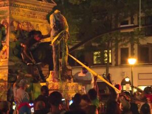 Участники акции протеста уронили статую на одного из митингующих