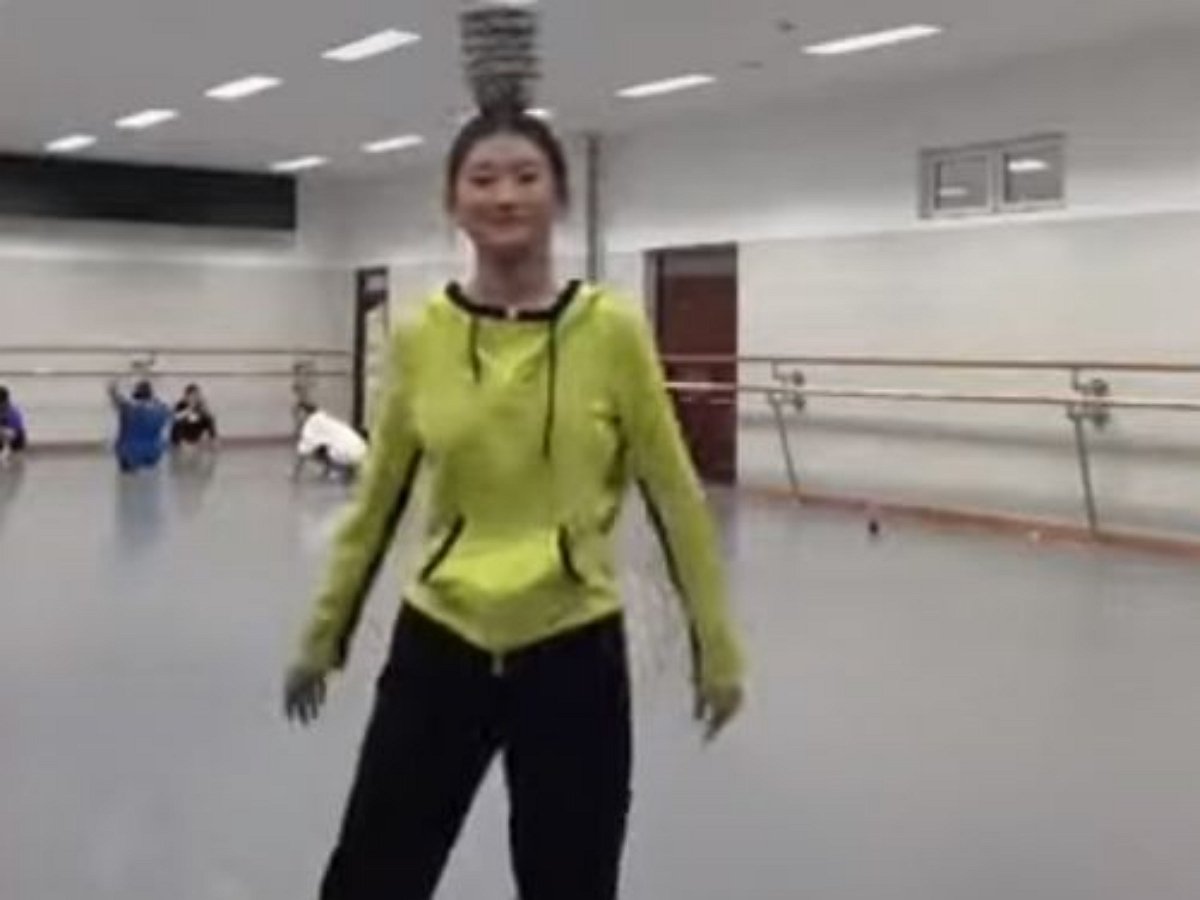 Ловкая плясунья танцует с посудой на голове